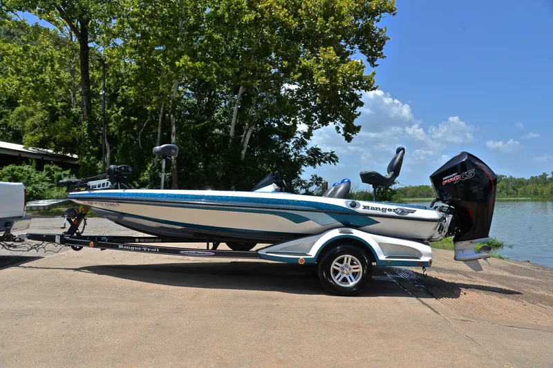 Slide: The Image of 2012 Ranger Z518 boat on trailer by a lake, surrounded by trees. - 11