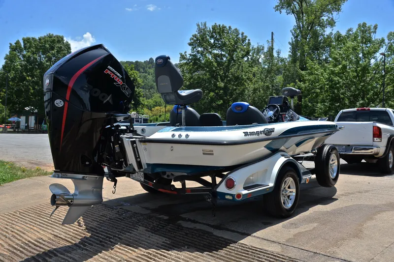 Slide: The Image of 2012 Ranger Z518 boat on trailer with powerful outboard motor, parked outdoors. - 14