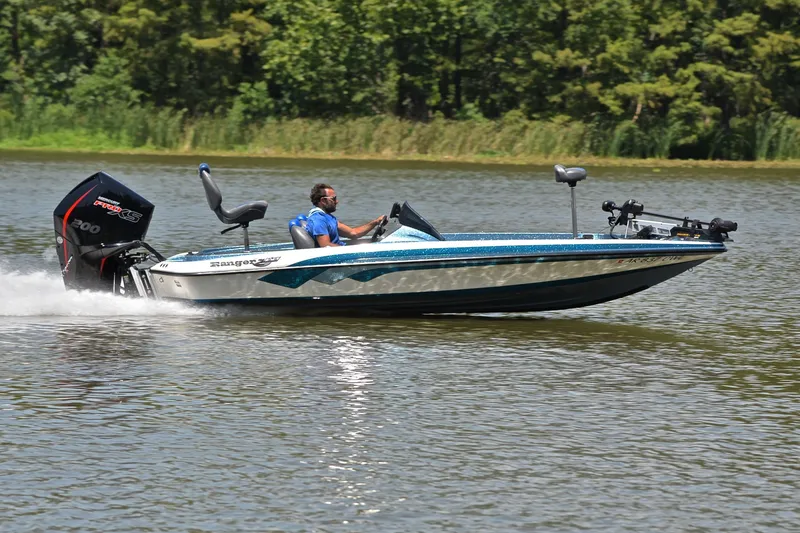 Slide: The Image of 2012 Ranger Z518 boat speeding on a lake with lush green trees in the background. - 3
