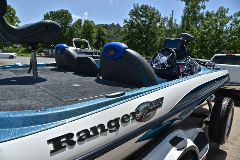 Slide: The Image of 2012 Ranger Z518 boat with sleek design, parked outdoors on a sunny day. - 19