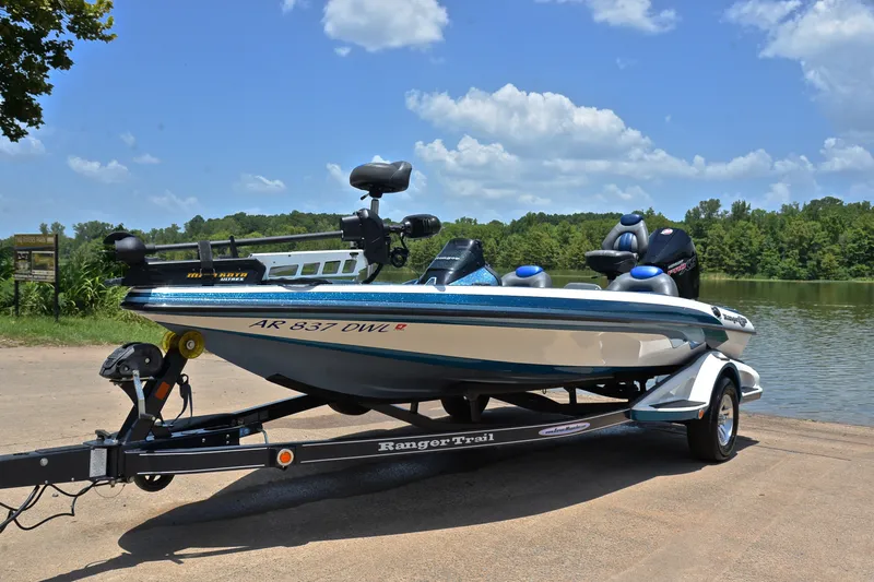 Slide: The Image of 2012 Ranger Z518 boat on trailer by a scenic lake under blue sky. - 10