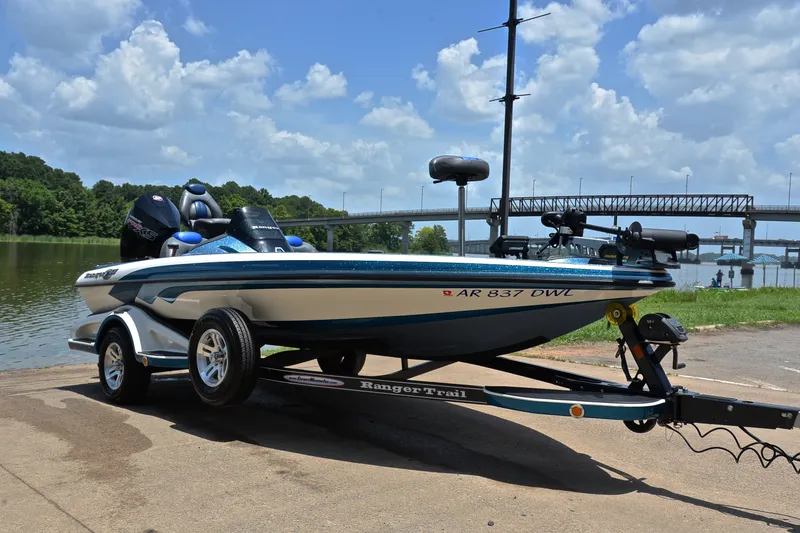 Slide: The Image of 2012 Ranger Z518 boat on trailer by a lake, under a blue sky. - 16