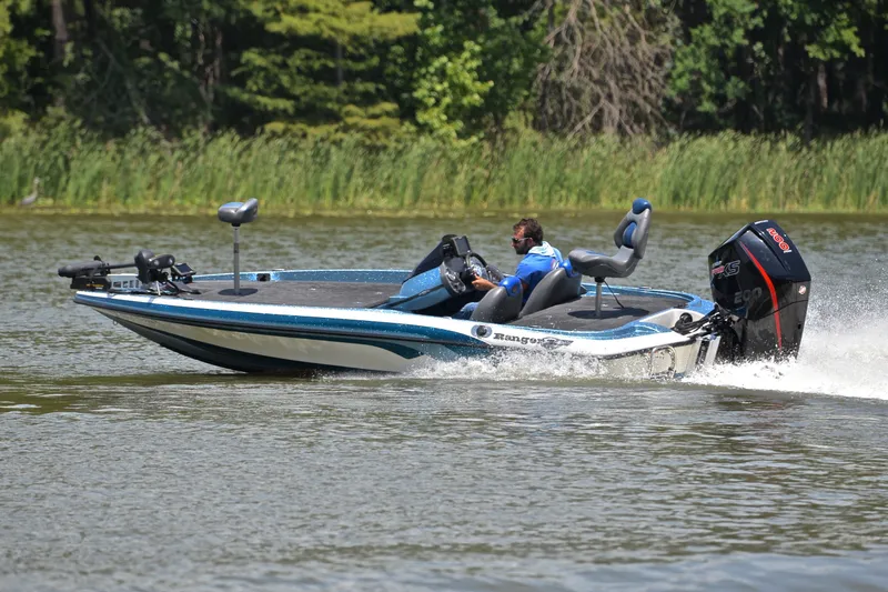Slide: The Image of 2012 Ranger Z518 boat speeding on a lake with lush green background. - 6