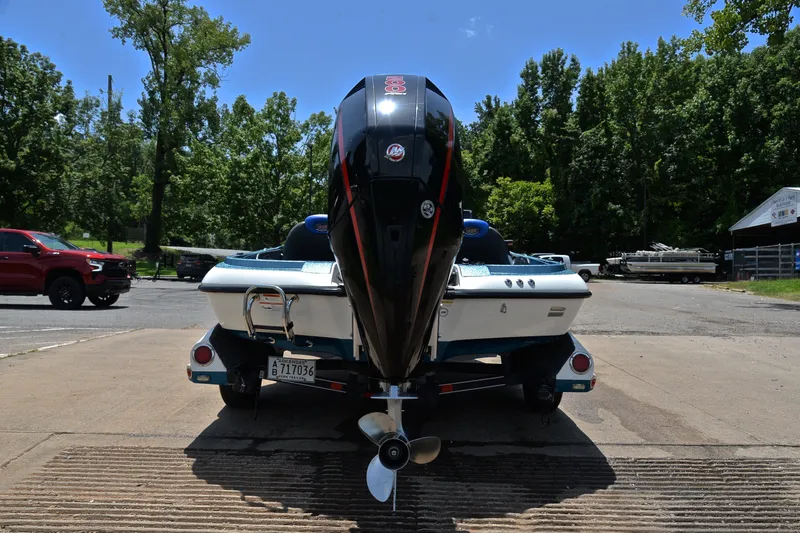 Slide: The Image of 2012 Ranger Z518 boat with outboard motor, parked on a sunny day near trees. - 13