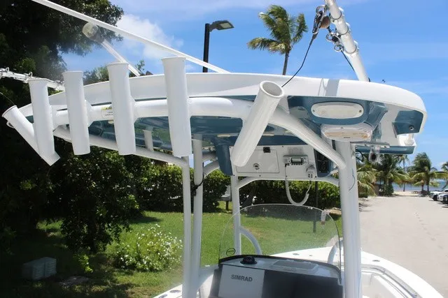 Slide: The Image of The image shows the T-top of a Sea Pro 219 Center Console boat with fishing rod holders. - 44