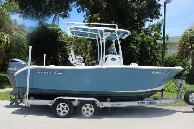 Slide: The Image of 2023 Sea Pro 219 Center Console on a trailer, featuring a blue hull and T-top. - 4