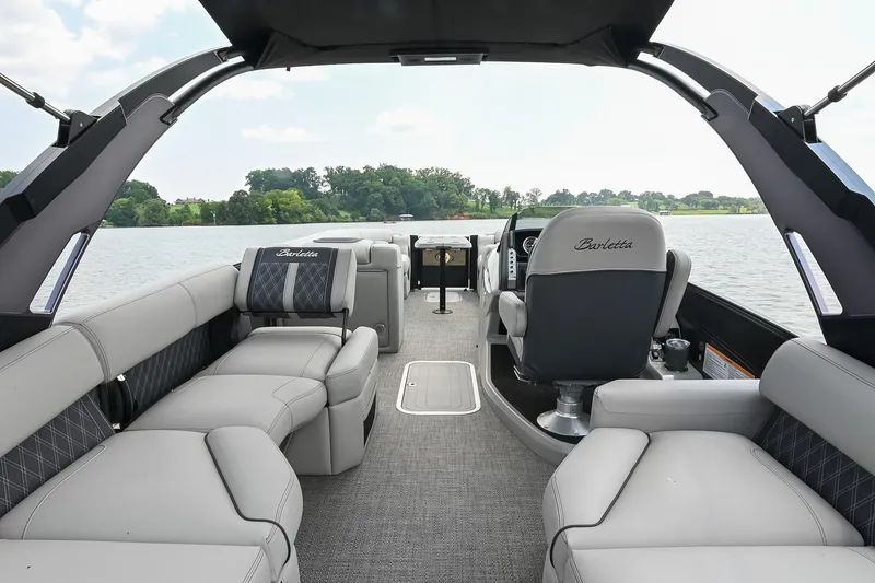 Slide: The Image of 2025 Barletta Lusso 25UCA pontoon boat interior with luxurious seating on a serene lake. - 7