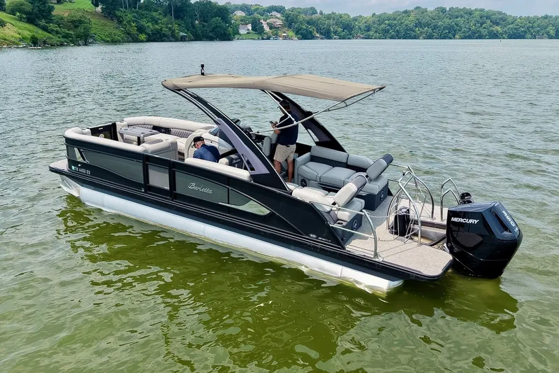 Slide: The Image of 2025 Barletta Lusso 25UCA pontoon boat on a scenic lake with lush green surroundings. - 54