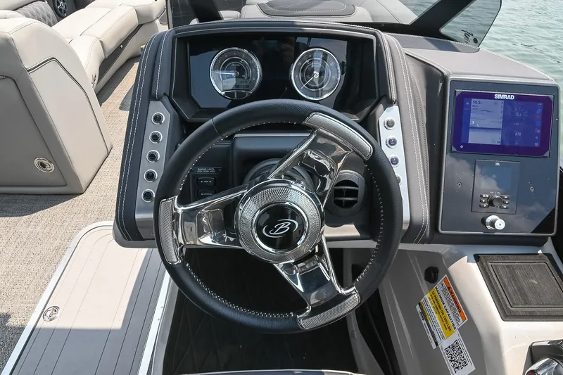 Slide: The Image of 2025 Barletta Lusso 25UCA boat dashboard with steering wheel and digital display. - 24