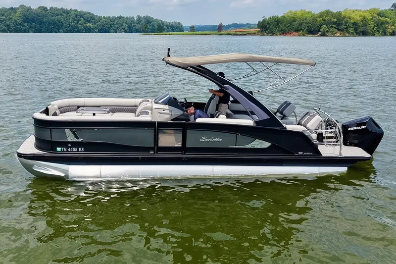 Slide: The Image of 2025 Barletta Lusso 25UCA pontoon boat on a serene lake with lush greenery. - 53