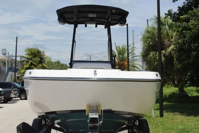 Slide: The Image of A white 2021 Yamaha 210 FSH Sport boat on a trailer, surrounded by trees. - 13