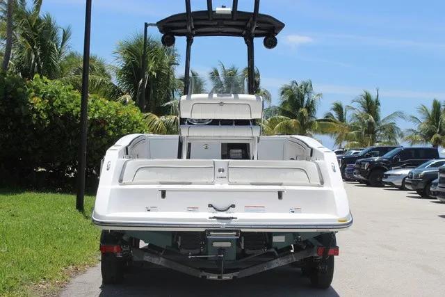 Slide: The Image of A 2021 Yamaha 210 FSH Sport boat on a trailer, surrounded by palm trees. - 5