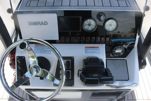 Slide: The Image of The image shows the helm of a 2021 Yamaha 210 FSH Sport boat with Simrad electronics. - 29