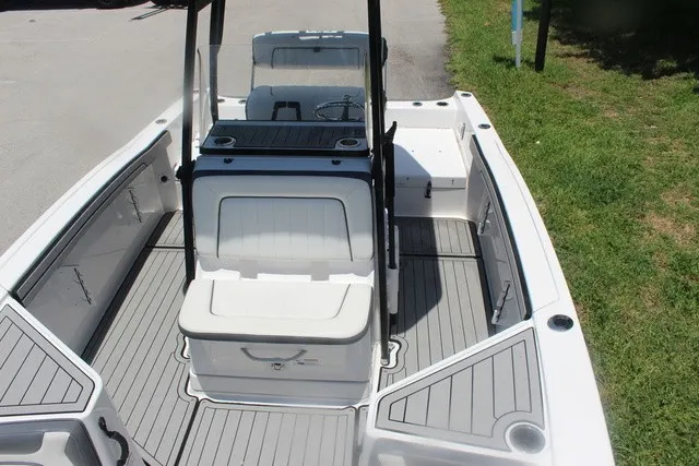 Slide: The Image of The image shows the deck of a 2021 Yamaha 210 FSH Sport boat with gray flooring and white seating. - 22