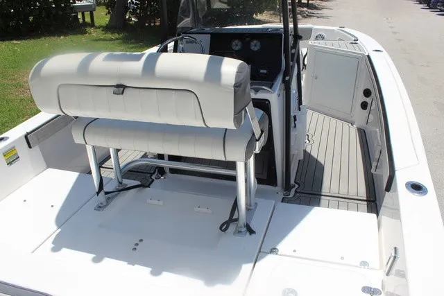 Slide: The Image of The image shows the cockpit of a 2021 Yamaha 210 FSH Sport boat with white upholstery. - 18