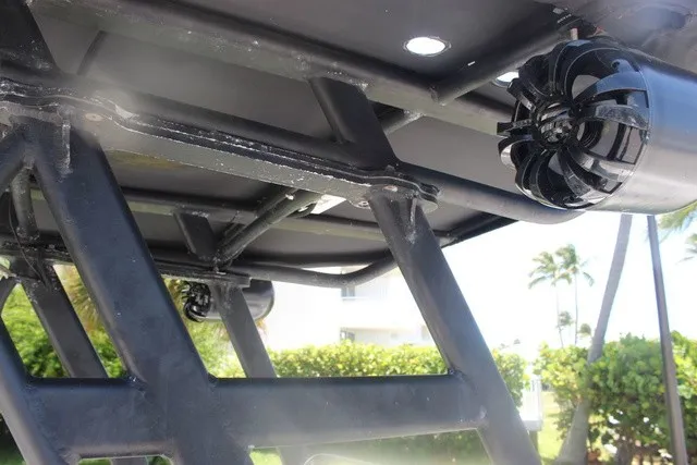Slide: The Image of Close-up of a black boat frame with speakers, surrounded by palm trees and blue sky. - 37