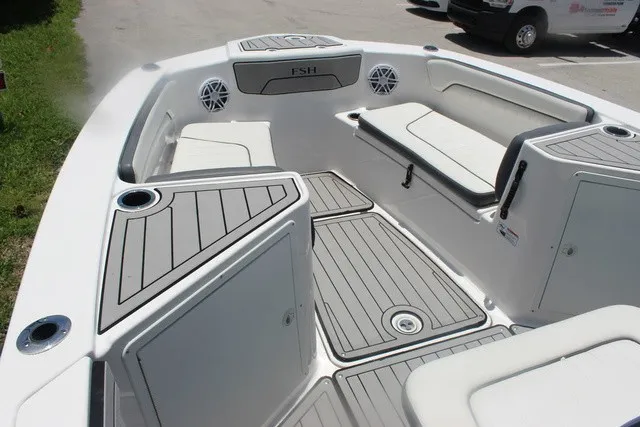 Slide: The Image of The image shows the deck of a Yamaha 210 FSH Sport boat with gray cushions and speakers. - 27