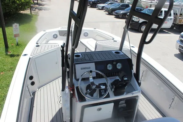 Slide: The Image of The image shows the cockpit of a 2021 Yamaha 210 FSH Sport boat with a helm console and steering wheel. - 15