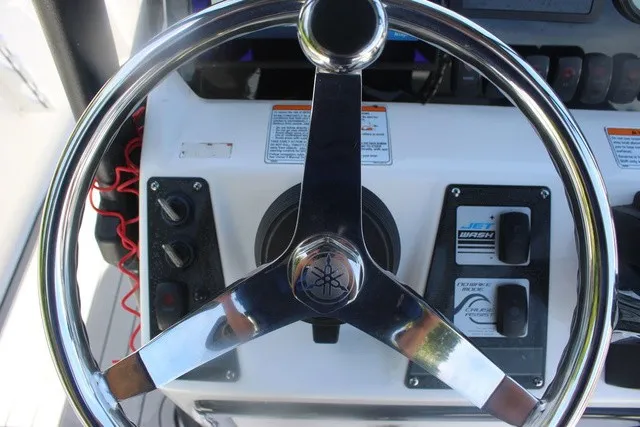 Slide: The Image of The image shows the helm of a Yamaha 210 FSH Sport boat with controls and gauges. - 34