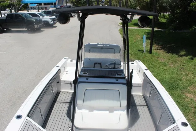 Slide: The Image of The image shows a 2021 Yamaha 210 FSH Sport boat with an open deck and T-top. - 25