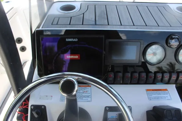 Slide: The Image of The image shows the dashboard of a Yamaha 210 FSH Sport with a Simrad display and various gauges. - 30