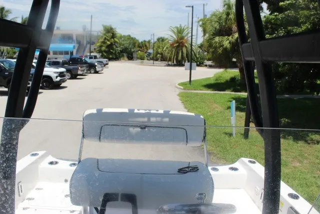 Slide: The Image of The image shows the cockpit of a 2021 Yamaha 210 FSH Sport boat, parked in a sunny area. - 40