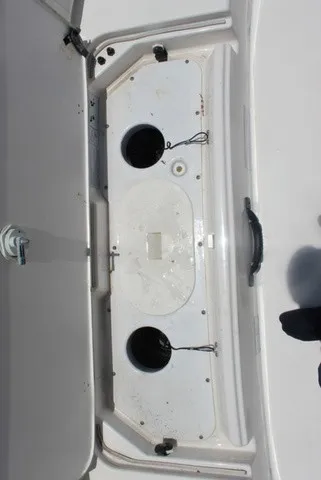 Slide: The Image of An open storage compartment on a Yamaha 210 FSH Sport boat, featuring two round openings. - 46
