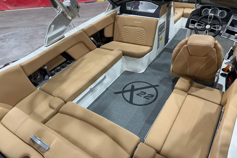 Slide: The Image of 2020 MasterCraft X22 boat interior with tan leather seating and modern dashboard. - 9