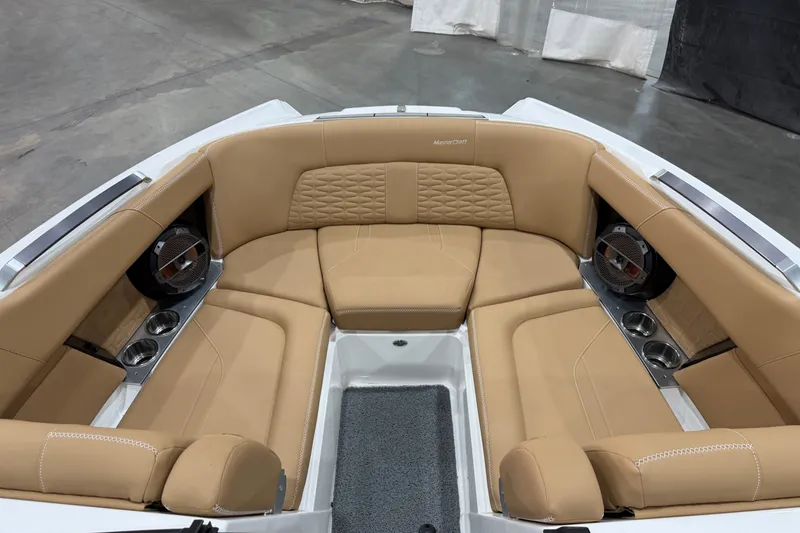 Slide: The Image of Luxurious tan seating in 2020 MasterCraft X22 boat interior, featuring cup holders and speakers. - 11