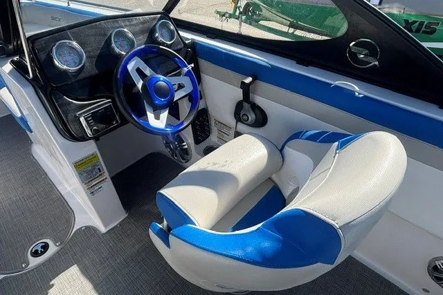 Slide: The Image of 2017 Starcraft SCX Surf 211 IO boat interior with blue and white seating and steering wheel. - 4