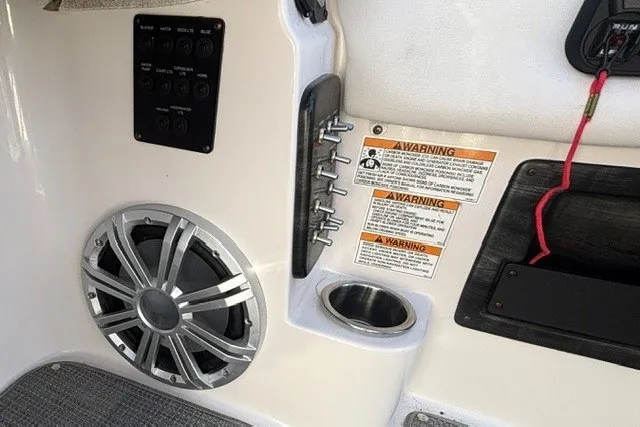 Slide: The Image of 2017 Starcraft SCX Surf 211 IO boat interior with speaker, control panel, and warning labels. - 11