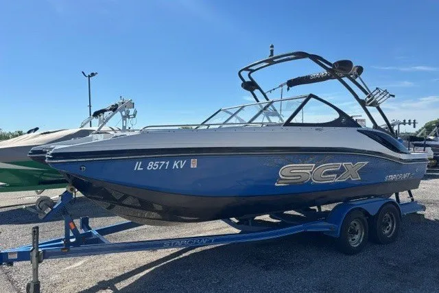 Slide: The Image of 2017 Starcraft SCX Surf 211 IO boat on trailer, blue and white design. - 3