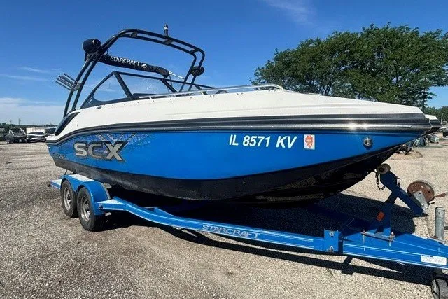 Slide: The Image of 2017 Starcraft SCX Surf 211 IO boat on trailer, blue and white design. - 16