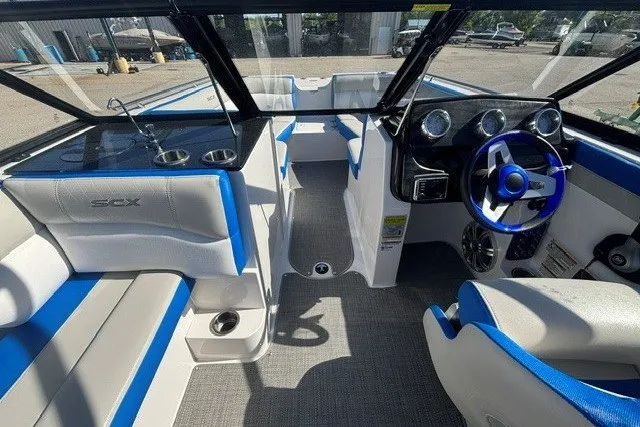 Slide: The Image of 2017 Starcraft SCX Surf 211 IO boat interior with blue and white seating, steering wheel, and dashboard. - 6