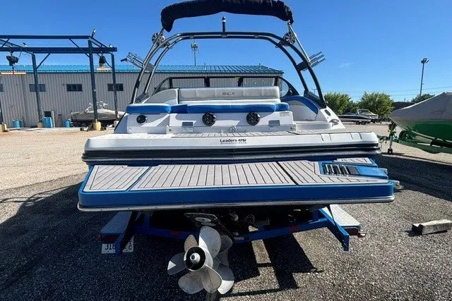 Slide: The Image of 2017 Starcraft SCX Surf 211 IO boat, rear view, on trailer in sunny marina. - 13