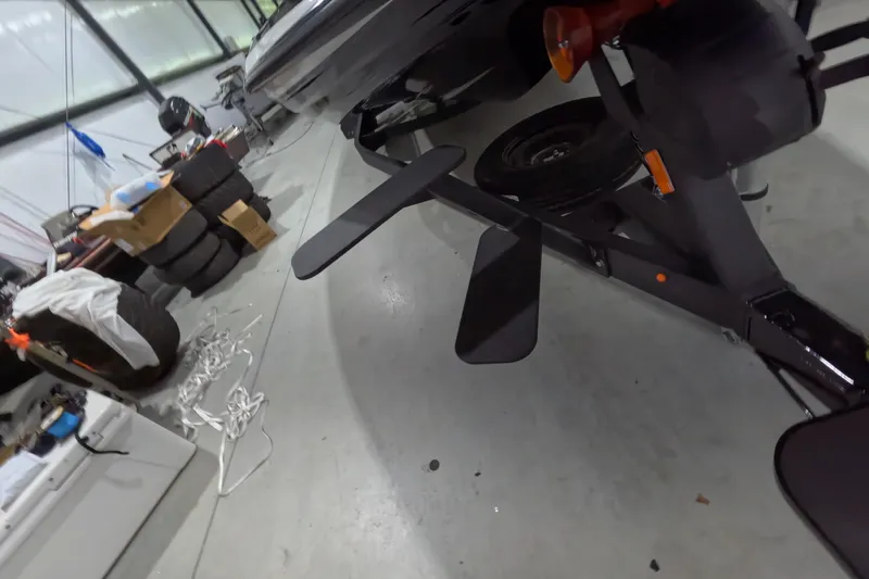 Slide: The Image of 2026 Skeeter ZXR21 SE boat trailer in a garage with tires and equipment. - 7
