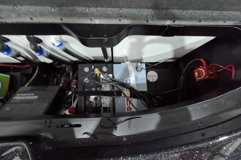 Slide: The Image of Battery compartment of a 2026 Skeeter ZXR21 SE boat, showcasing wiring and components. - 20