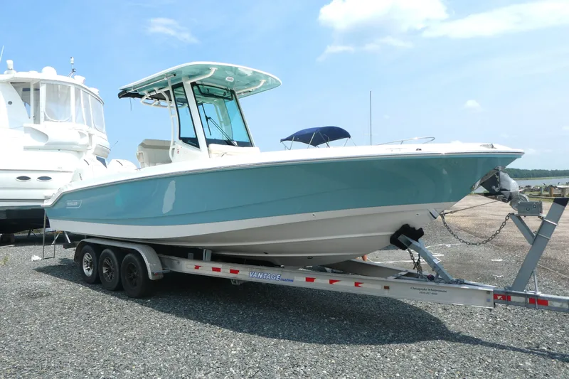 Slide: The Image of 2027 Boston Whaler 280 Dauntless boat on trailer, parked outdoors under clear sky. - 1