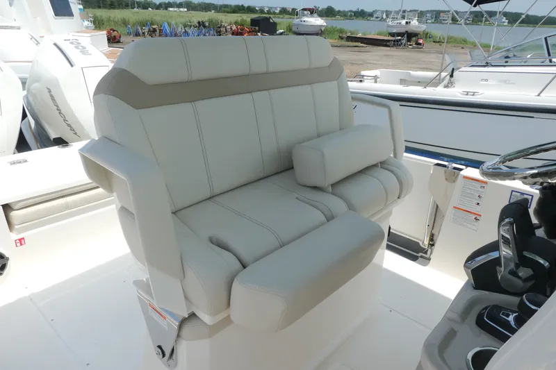 Slide: The Image of 2027 Boston Whaler 280 Dauntless boat interior with plush seating and steering console. - 9