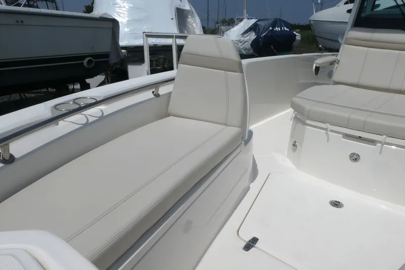 Slide: The Image of 2027 Boston Whaler 280 Dauntless boat interior with white cushioned seating. - 13