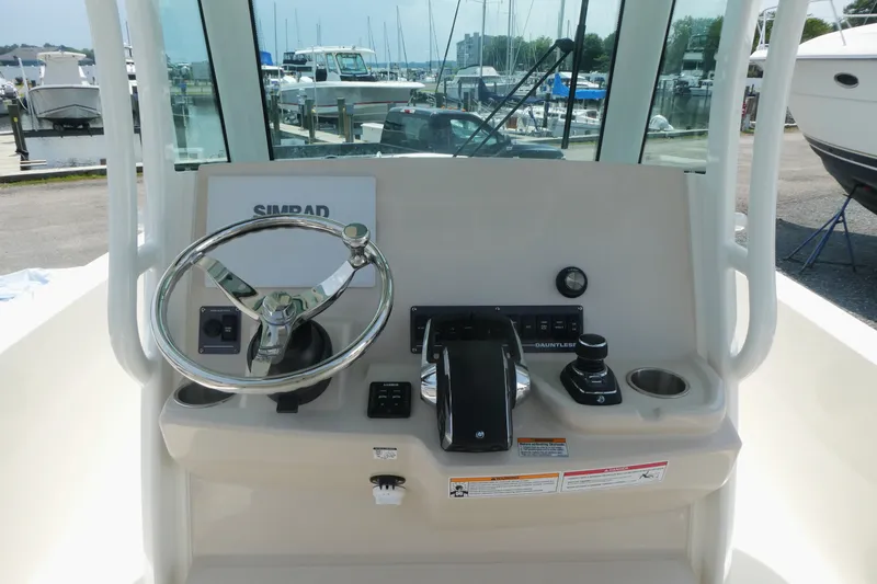 Slide: The Image of Boston Whaler 280 Dauntless 2027 helm with steering wheel and controls at marina. - 8