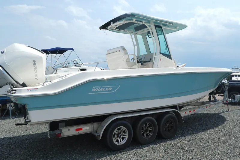 Slide: The Image of 2027 Boston Whaler 280 Dauntless boat on trailer, side view, blue and white design. - 2