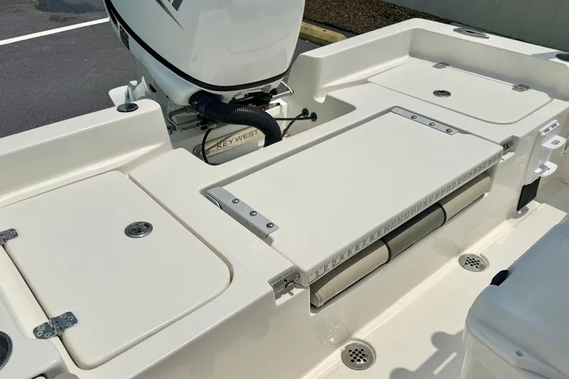 Slide: The Image of 2025 Key West 188 Bay Reef boat deck with storage compartments and motor. - 25