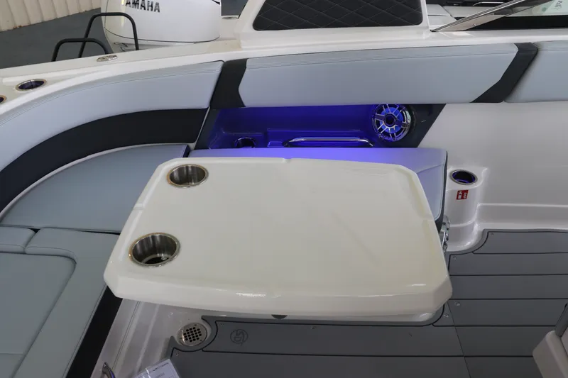 Slide: The Image of 2026 Chaparral 280 OSX boat interior with seating, table, and cup holders. - 16