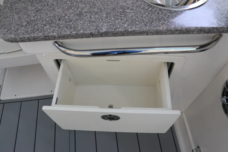 Slide: The Image of Open storage drawer on 2026 Chaparral 280 OSX boat with sleek countertop. - 19