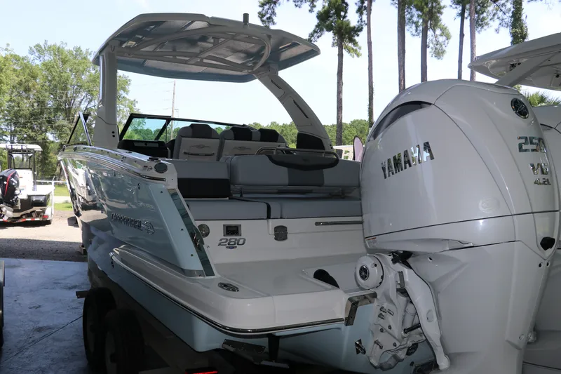 Slide: The Image of 2026 Chaparral 280 OSX boat with Yamaha outboard engines, parked outdoors. - 2