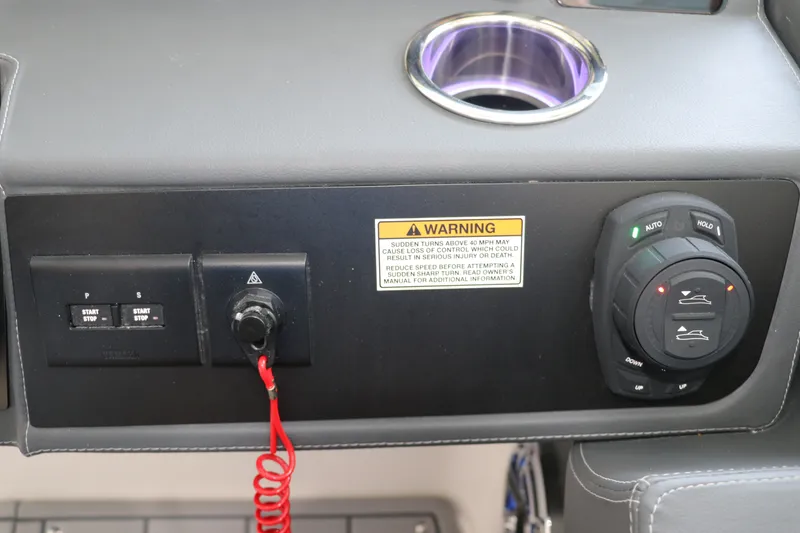 Slide: The Image of Control panel of 2026 Chaparral 280 OSX boat with warning label and cup holder. - 28