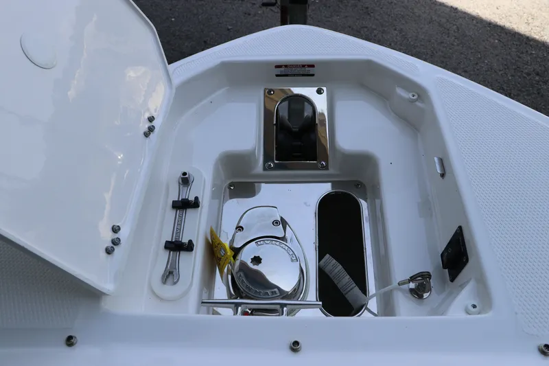 Slide: The Image of 2026 Chaparral 280 OSX boat anchor compartment with open hatch and visible winch. - 44