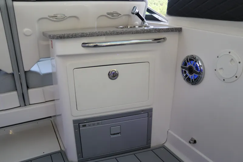 Slide: The Image of 2026 Chaparral 280 OSX boat interior with sink, storage, and speaker. - 17