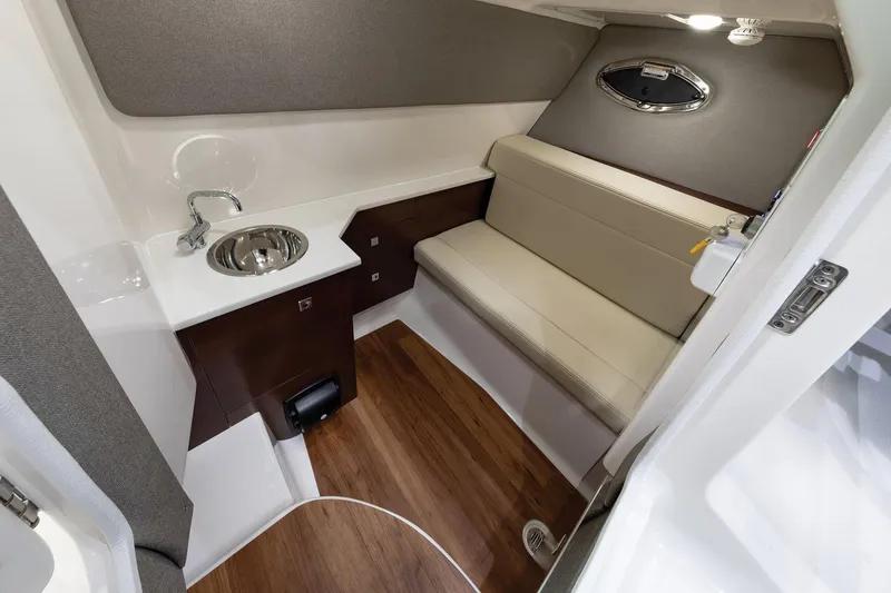 Slide: The Image of Manufacturer Provided Image: 2025 Chaparral 280 OSX cabin interior with sink, seating, and wood flooring. - 11